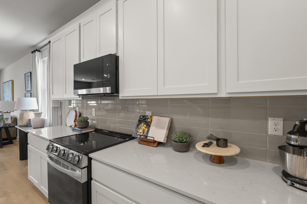 A kitchen with white cabinets.