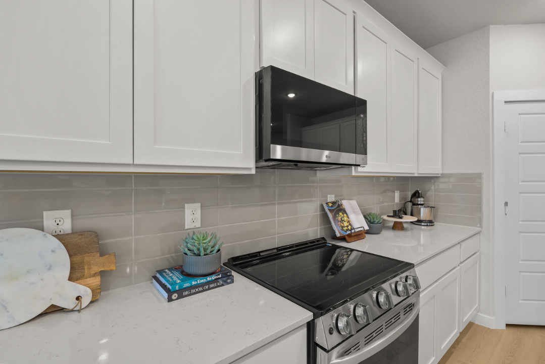 A kitchen with white cabinets.