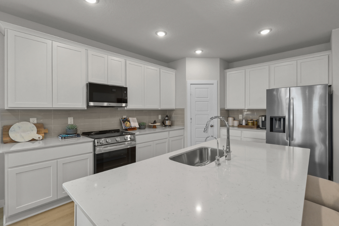 A kitchen with white cabinets.
