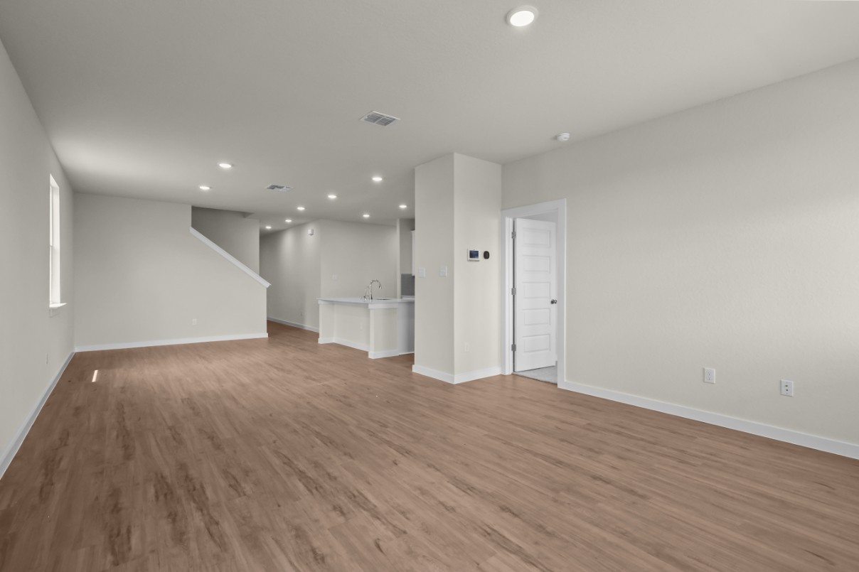 A room with white walls and wood floors.