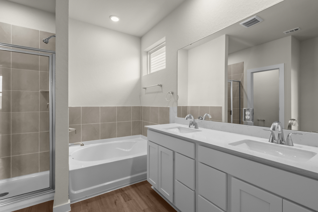A bathroom with a tub sink and a shower.