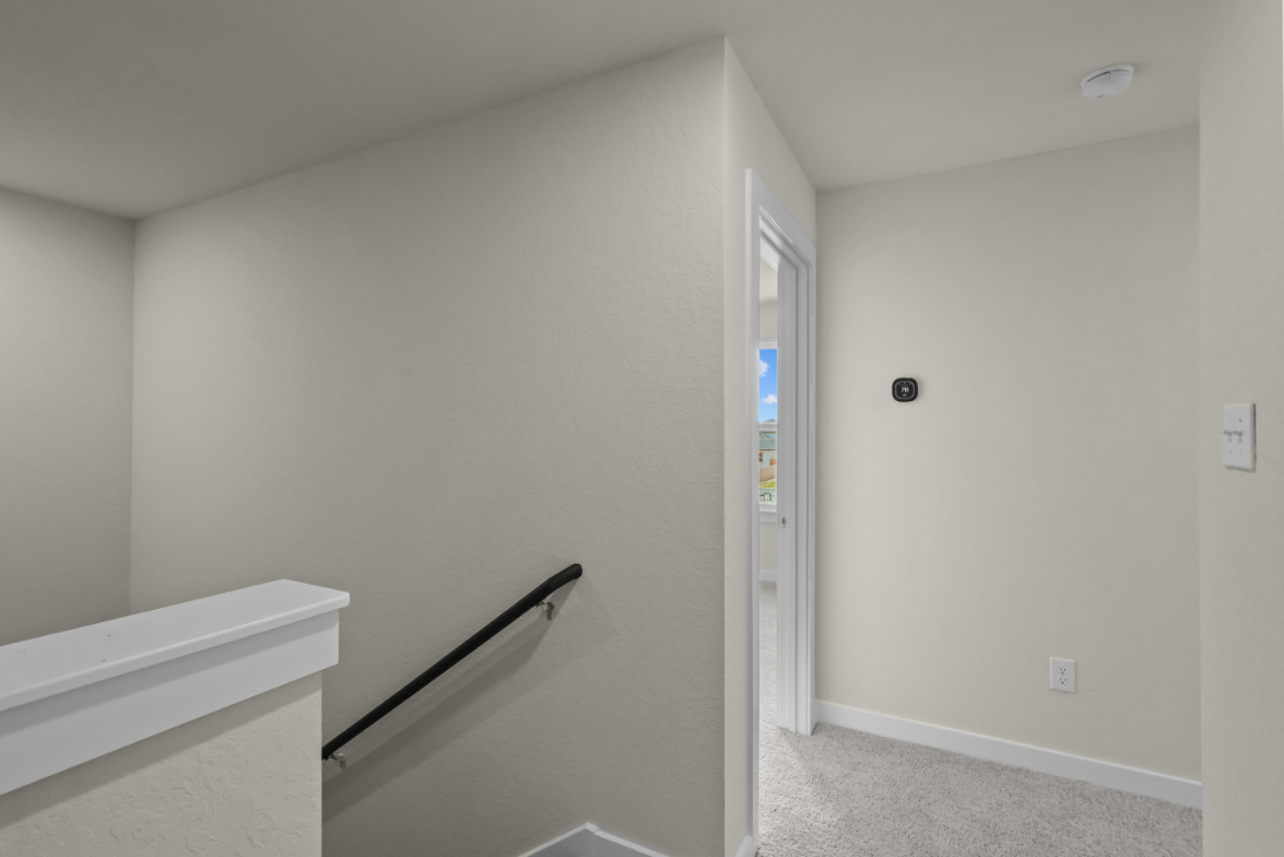 A white room with a door and a bench.