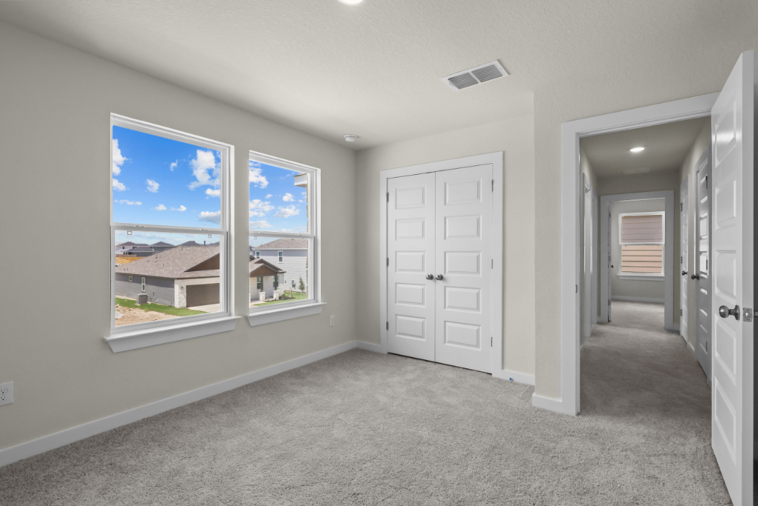 A room with white doors and a window with a view of a city.