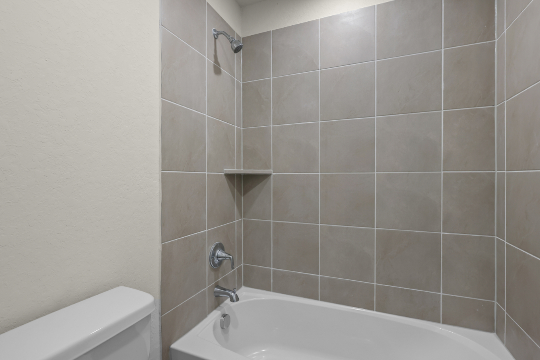 A bathroom with a bathtub and toilet.