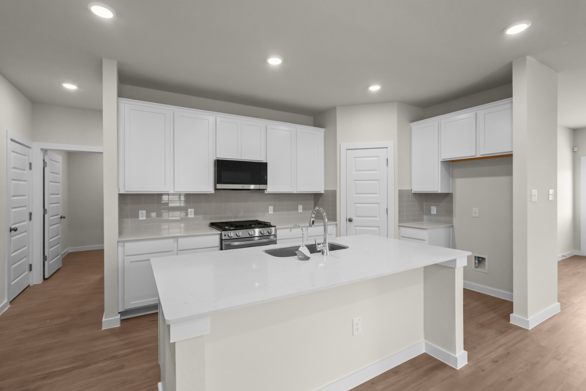 A kitchen with white cabinets.