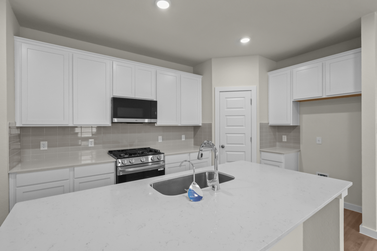 A kitchen with white cabinets.
