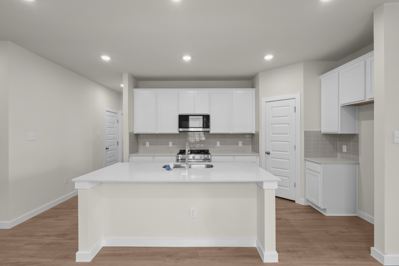 A kitchen with white cabinets.
