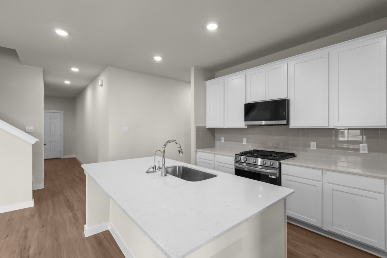 A kitchen with white cabinets.