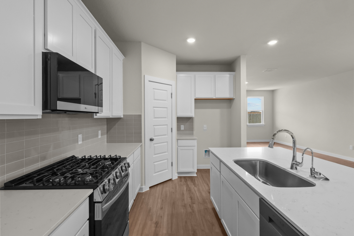 A kitchen with white cabinets.