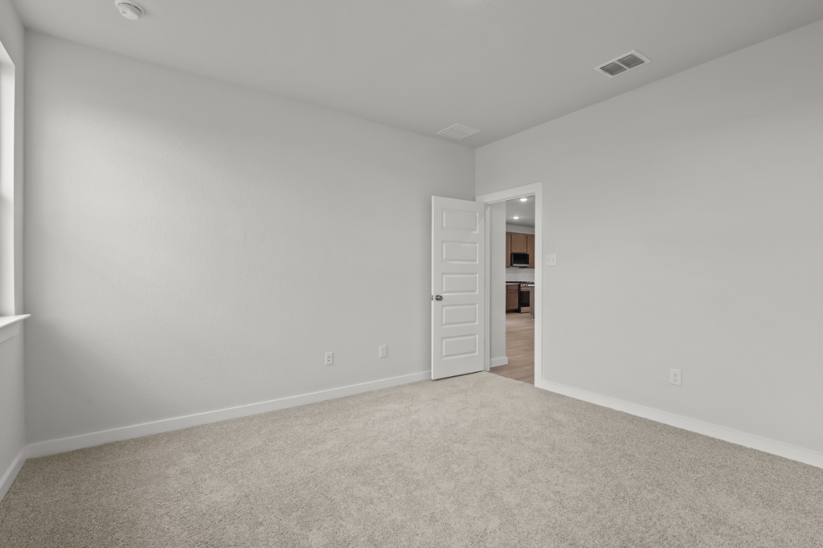 A room with a carpet and a door.