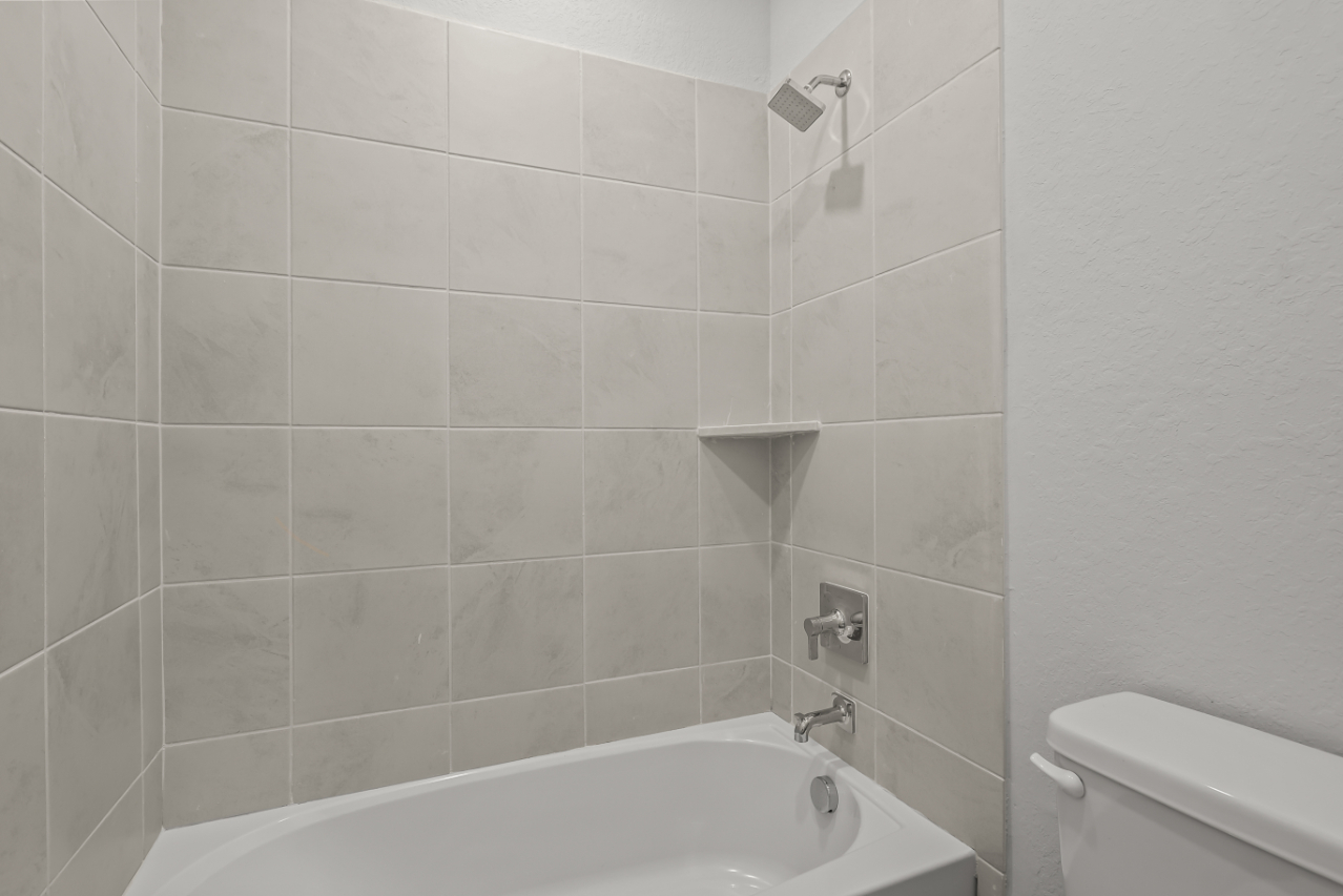 A bathroom with a bathtub and toilet.