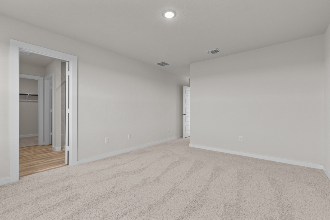 A room with a carpet and a door.