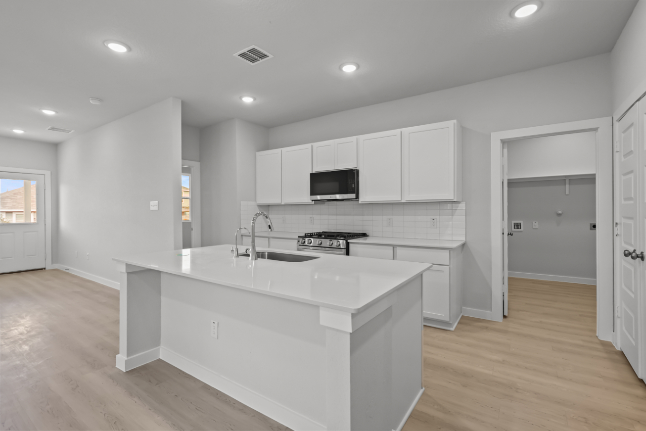 A kitchen with white cabinets.