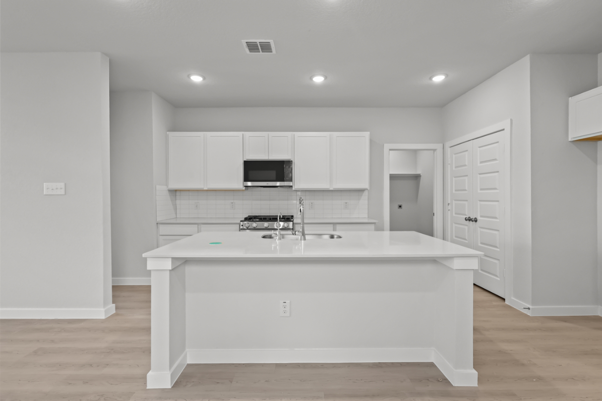 A kitchen with white cabinets.