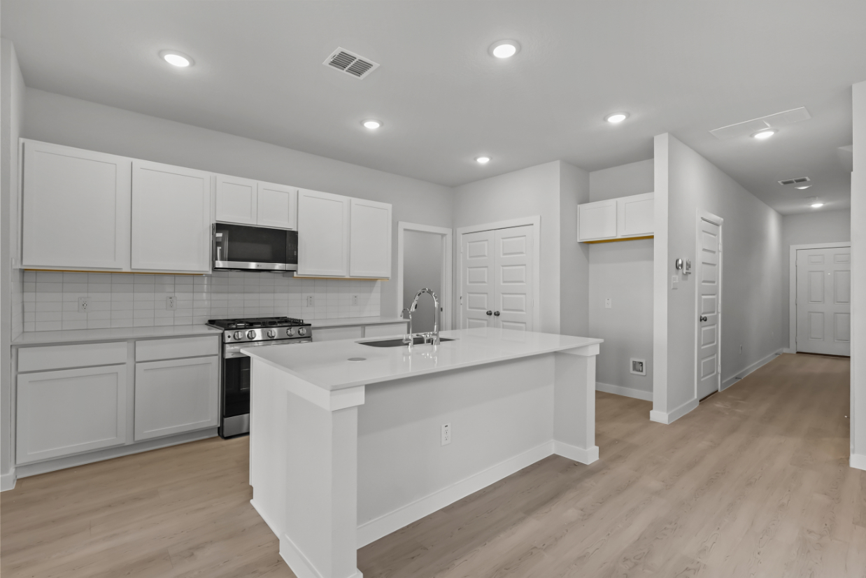 A kitchen with white cabinets.