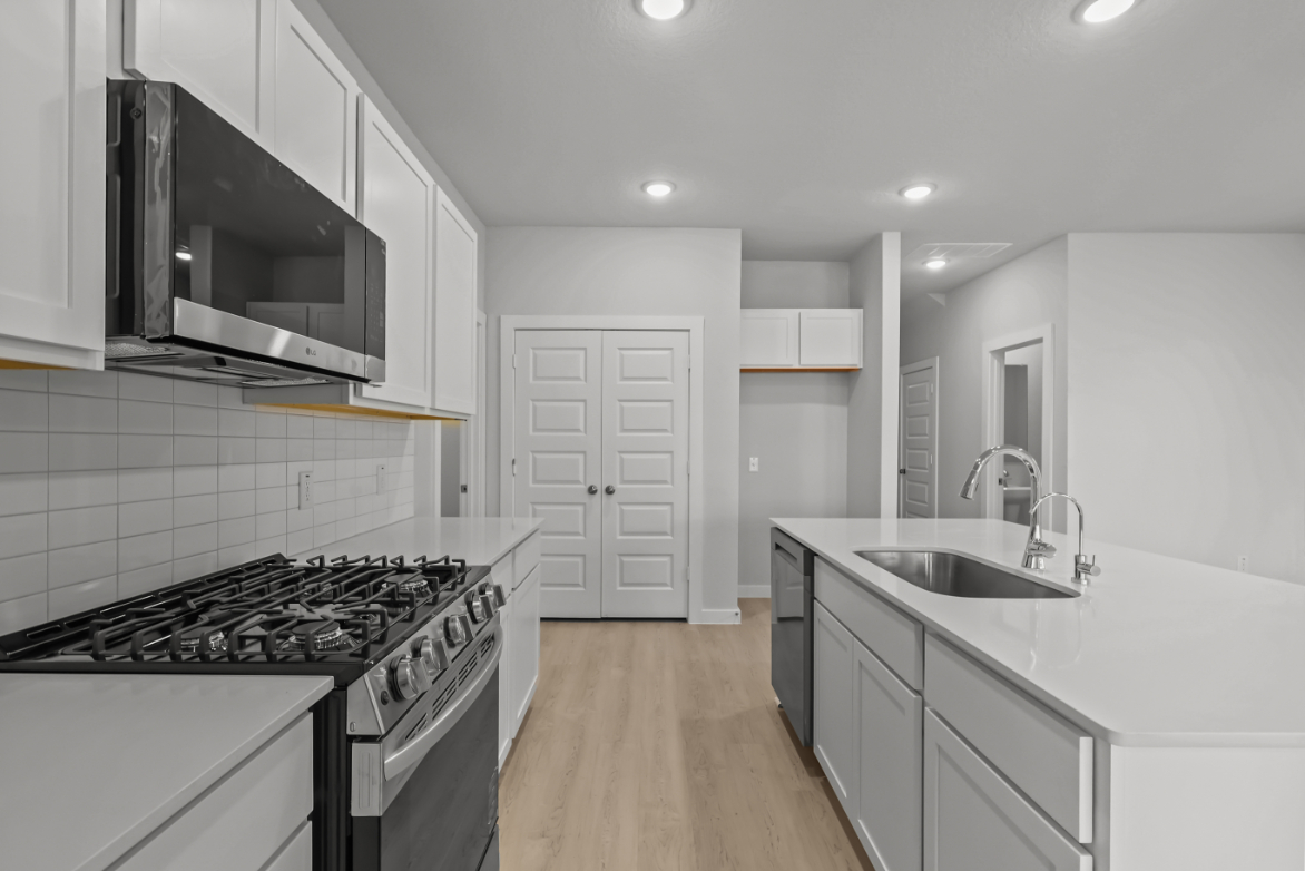 A kitchen with white cabinets.