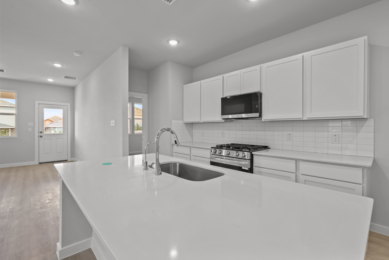 A kitchen with white cabinets.