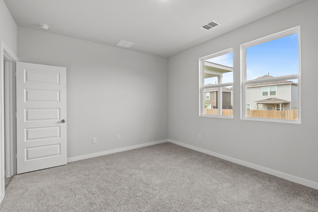 A room with white walls and a white door with a window.