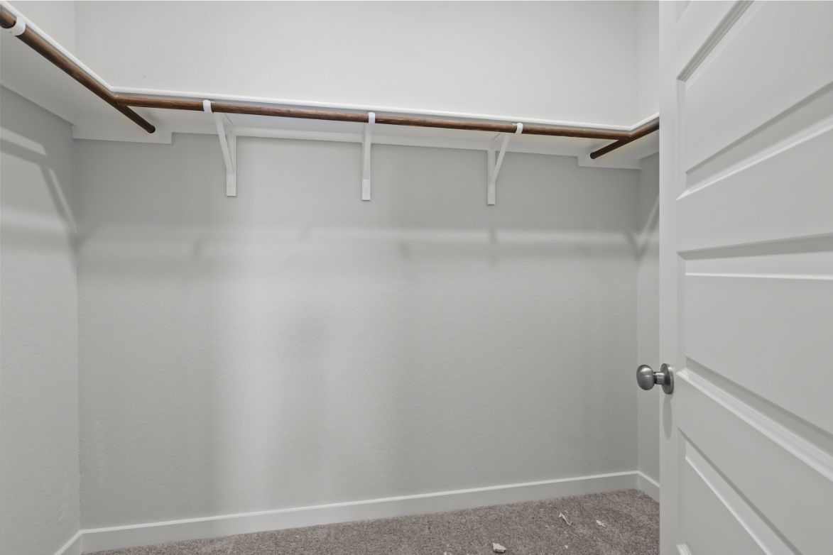 A white wall with a metal bar.