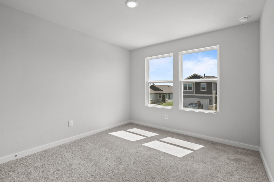 A room with a window and a rug.