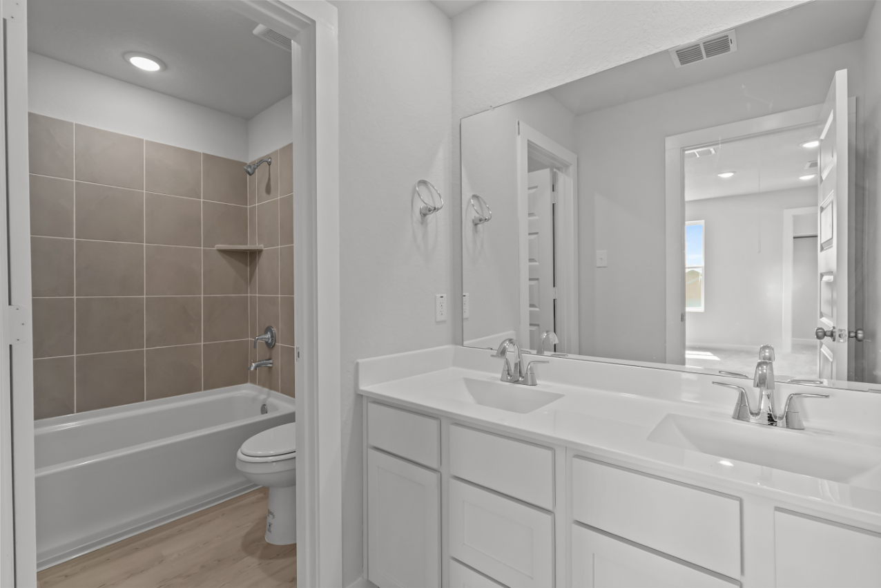 A bathroom with a tub sink and toilet.