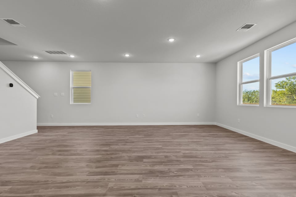 A room with a wood floor and windows.