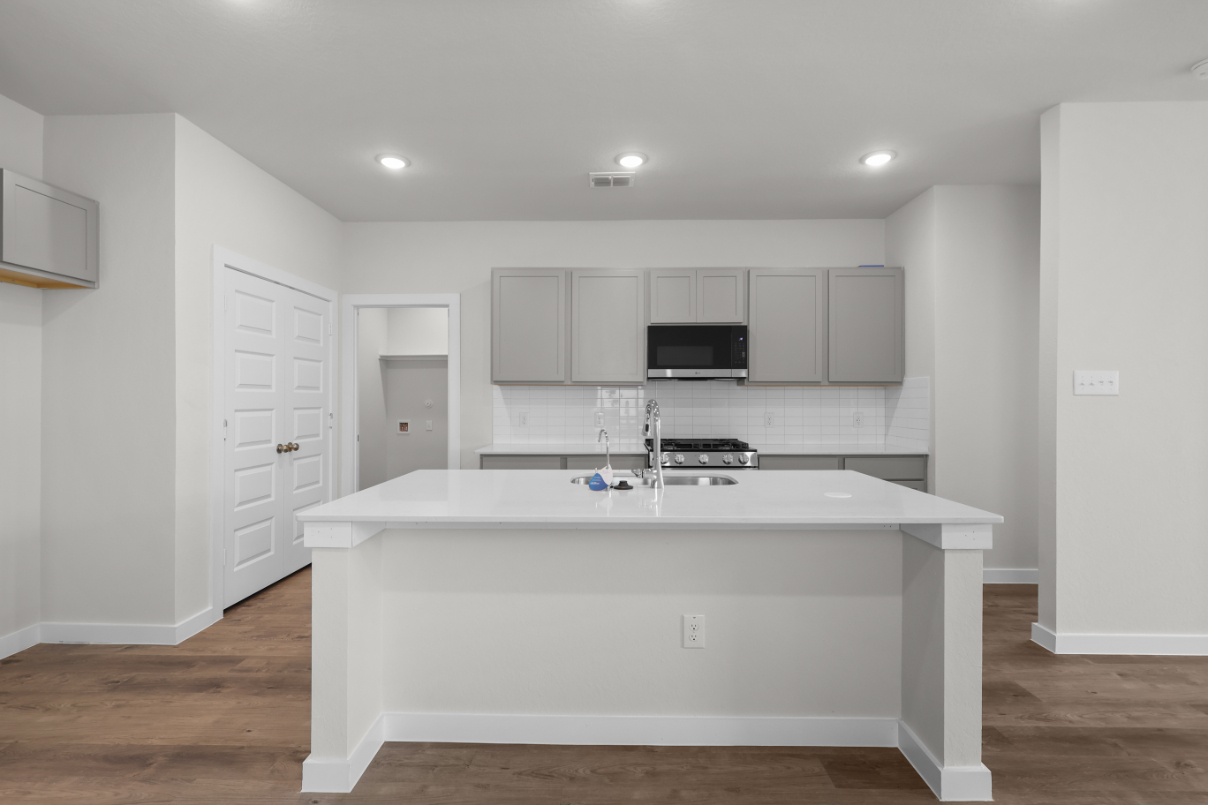 A kitchen with white cabinets.