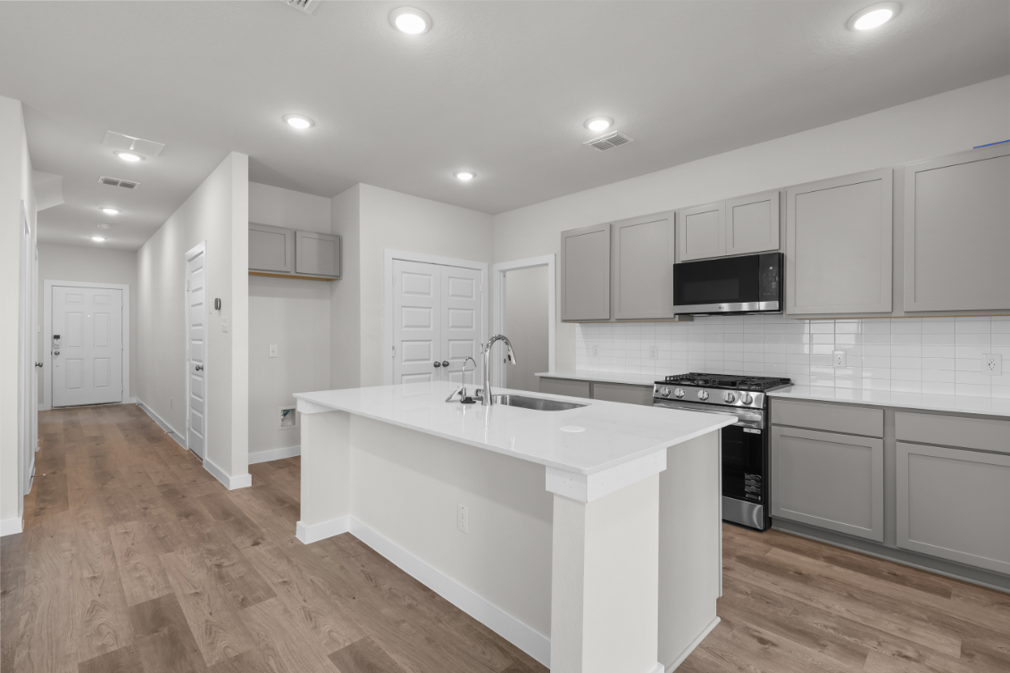 A kitchen with white cabinets.