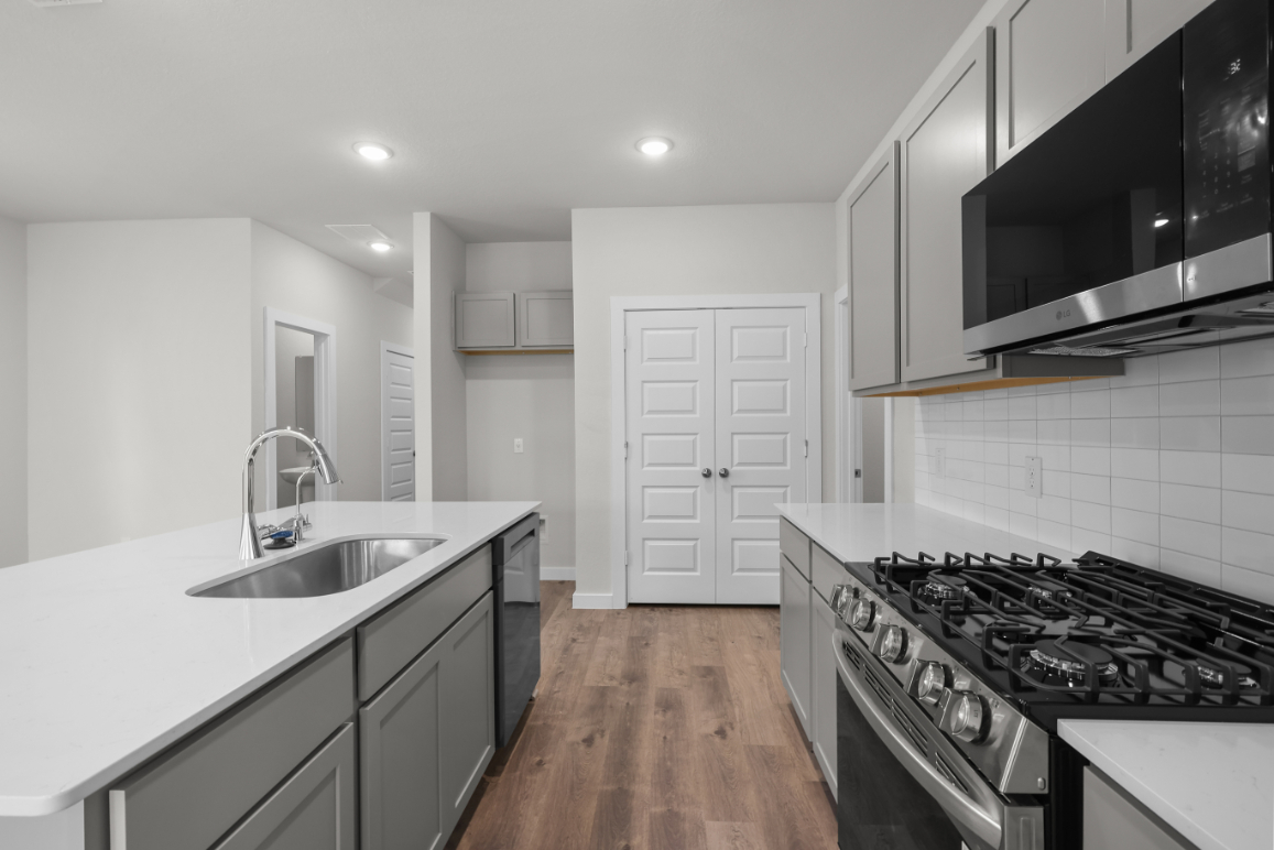 A kitchen with white cabinets.