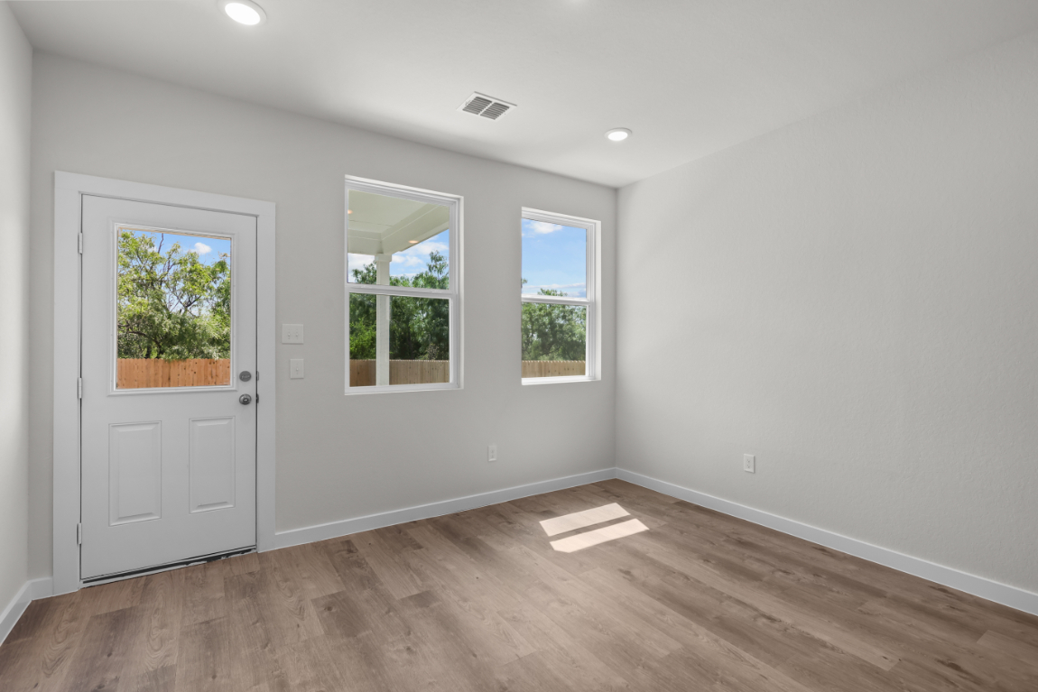 A room with windows and a wood floor.