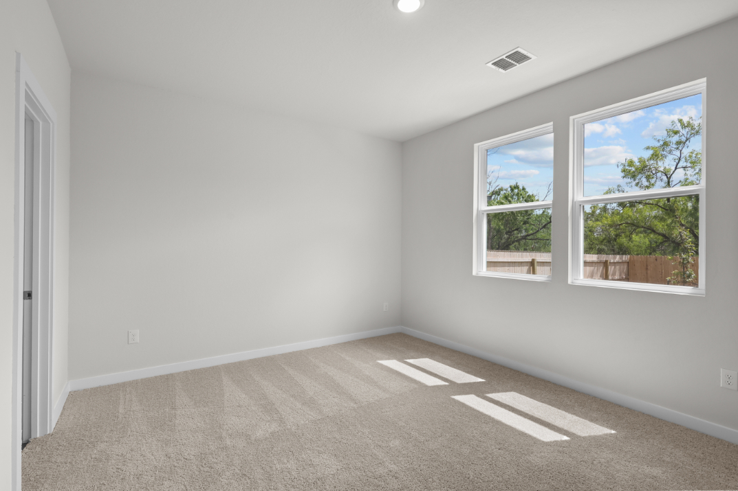 A room with windows and a rug.