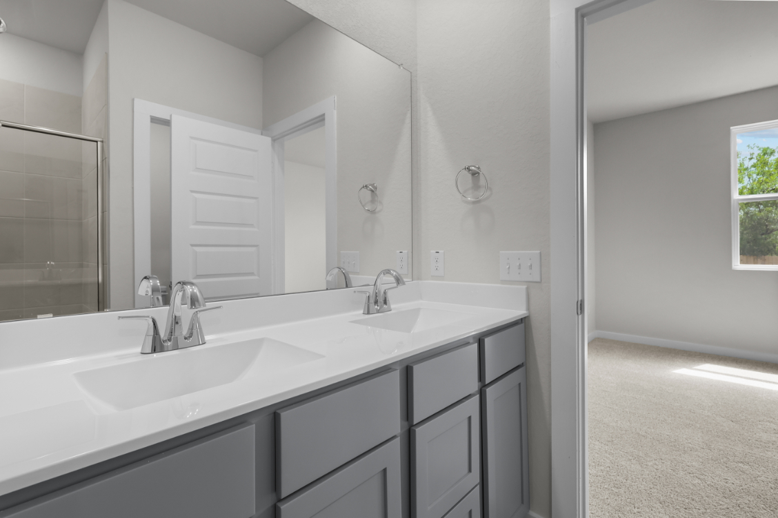 A bathroom with white cabinets.