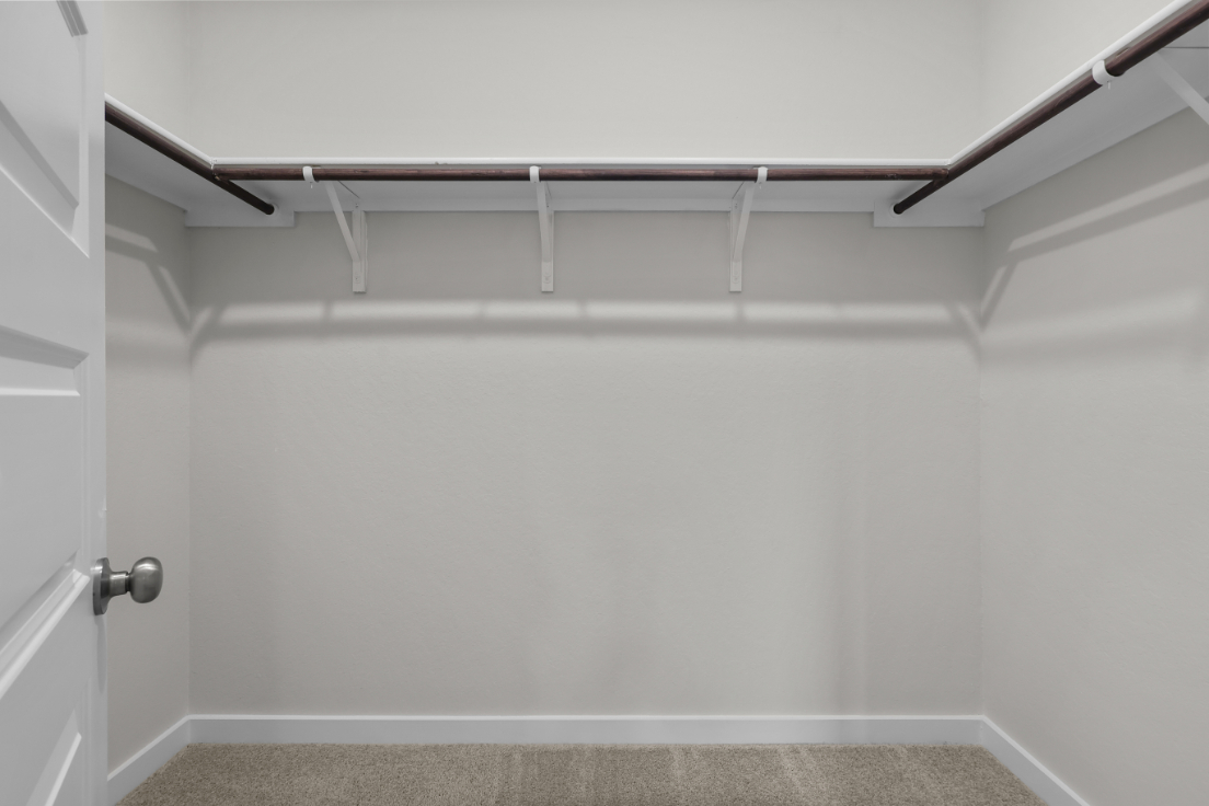A white wall with a metal bar.