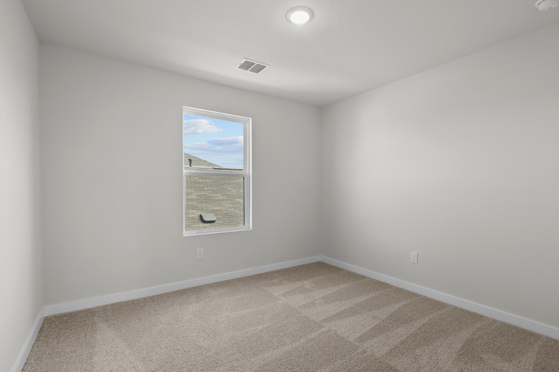 A room with a window and a rug.