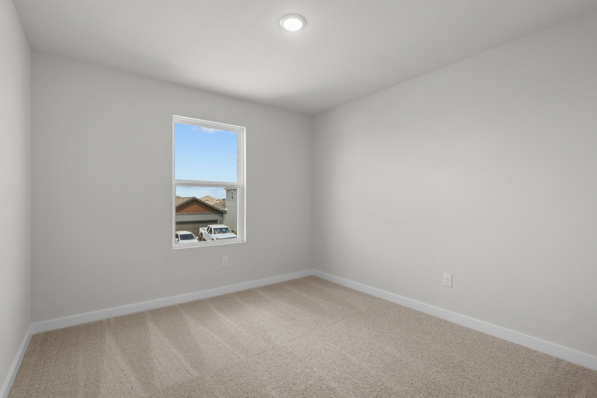 A room with a window and a carpet.