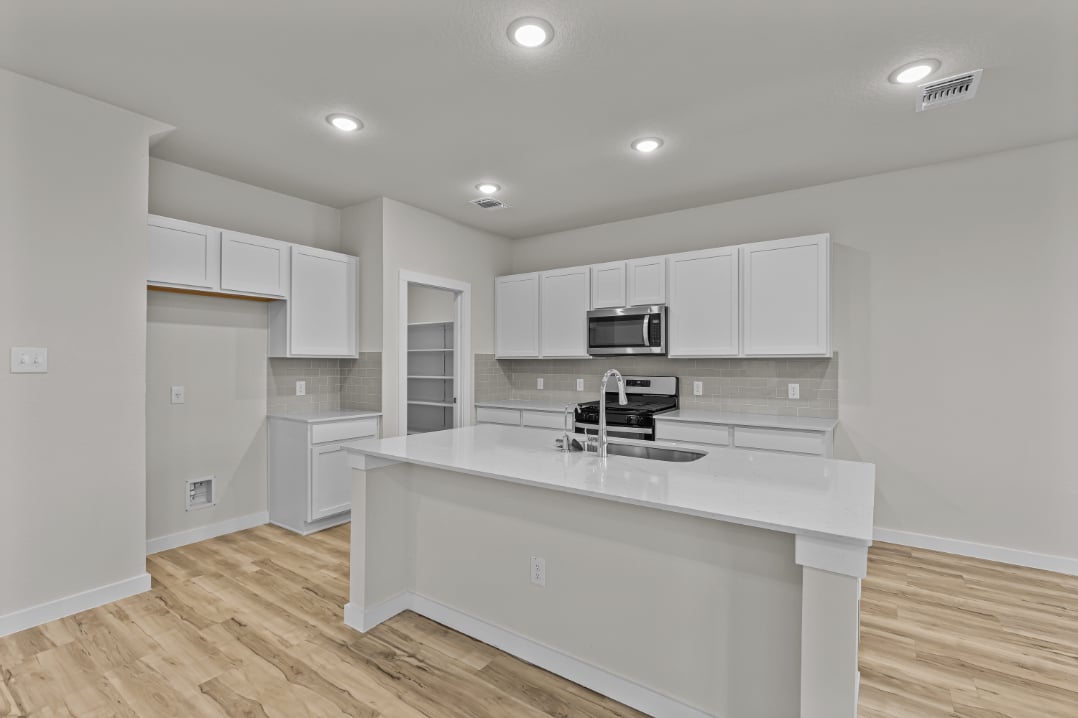 A kitchen with white cabinets.