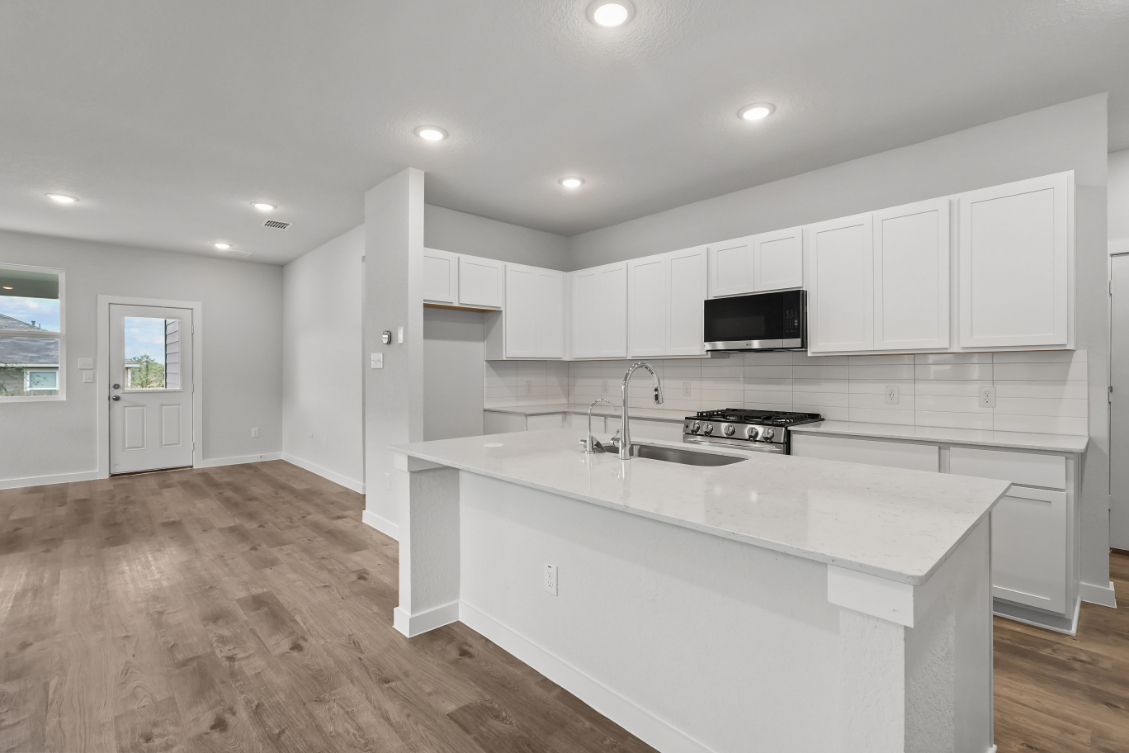 A kitchen with white cabinets.