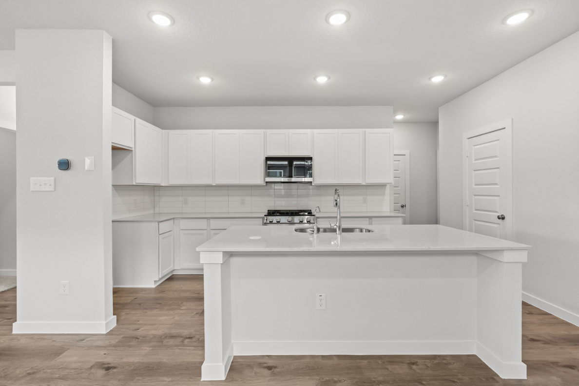 A kitchen with white cabinets.