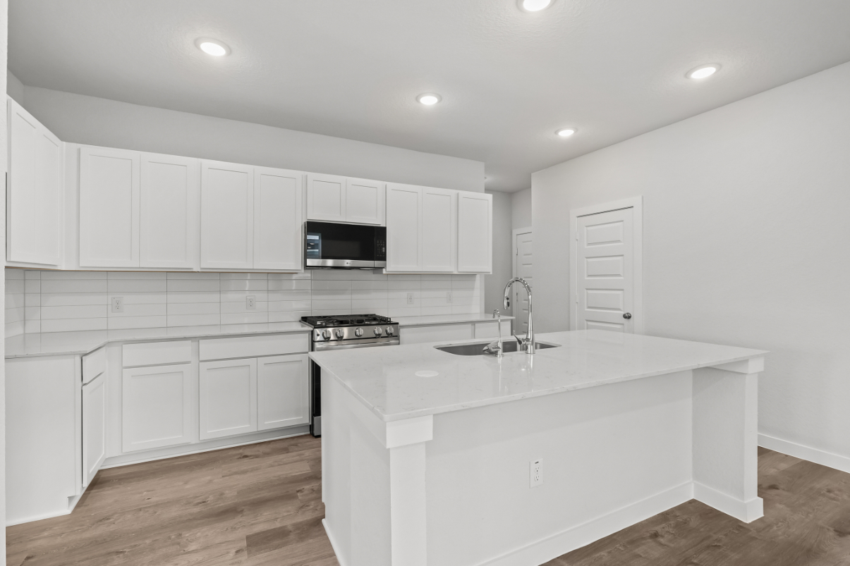 A kitchen with white cabinets.