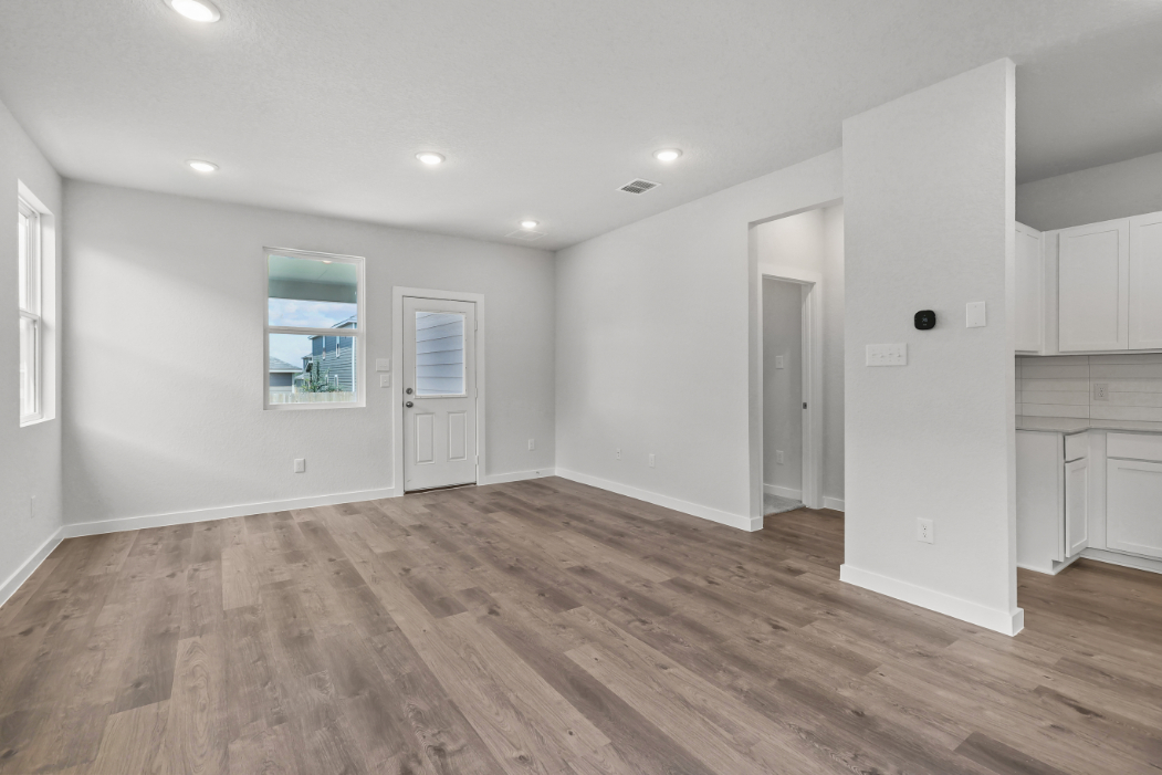 A room with white walls and wood floors.