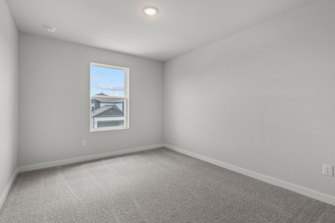 A room with a window and a wall with a painting on it.