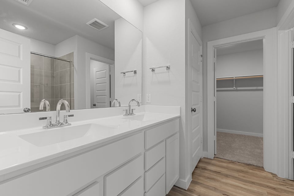 A bathroom with white cabinets.