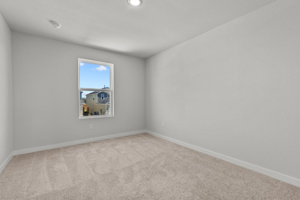 A room with a window and a carpet.