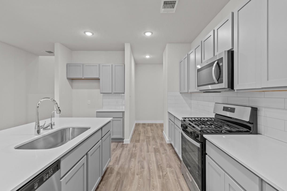 A kitchen with white cabinets.
