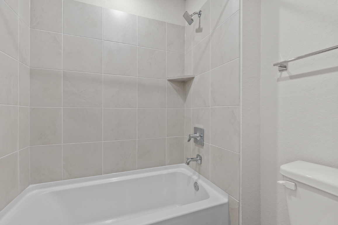 A bathroom with a bathtub and toilet.