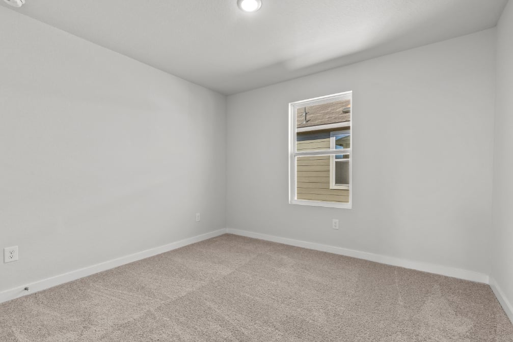 A room with a window and carpet.