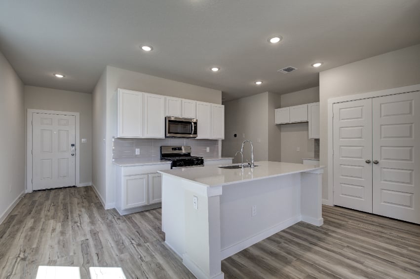 A kitchen with white cabinets.