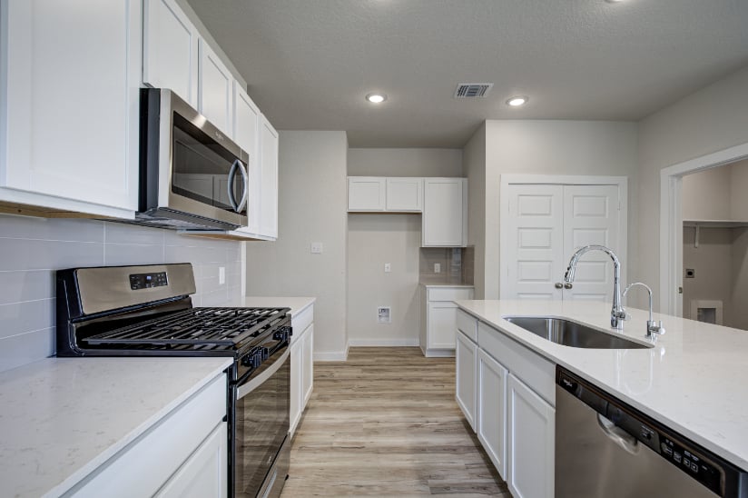 A kitchen with white cabinets.