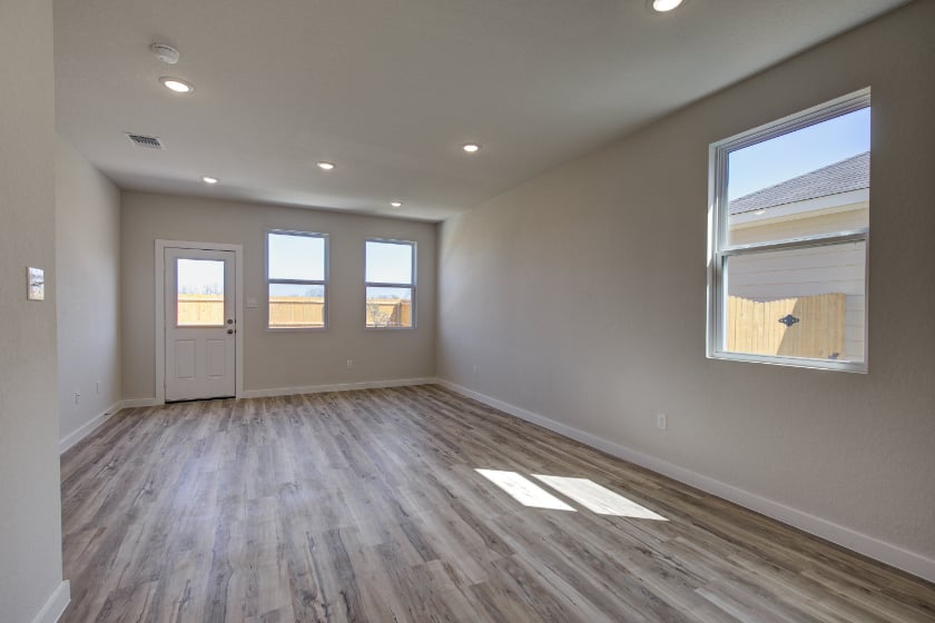 A room with a wood floor and windows.