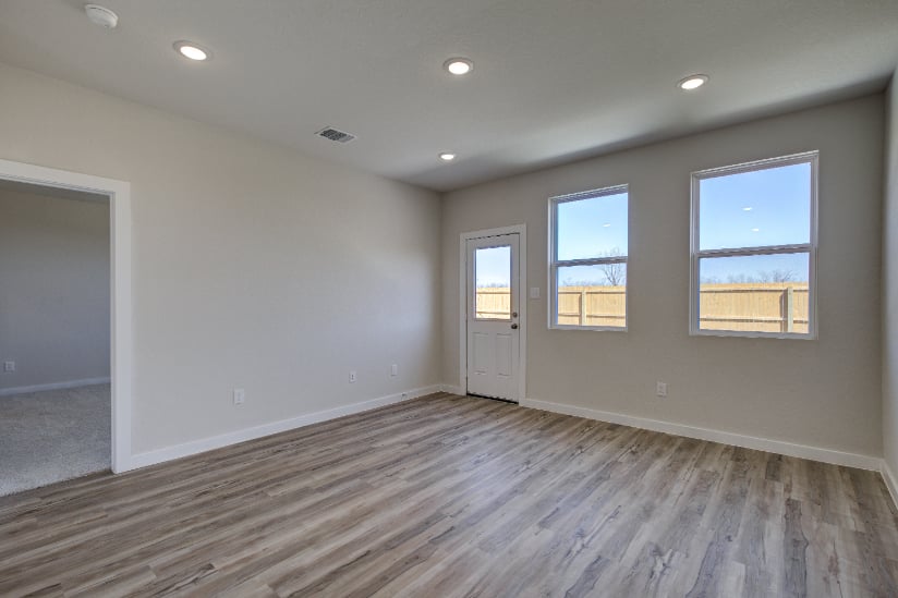 A room with a wood floor and windows.